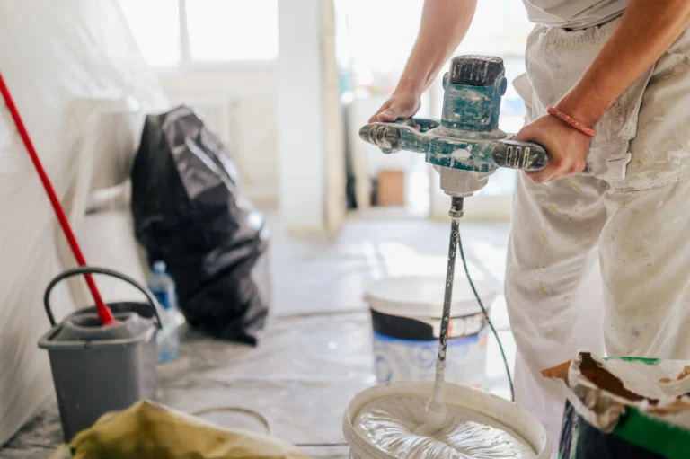 pintor removiendo pintura con máquina